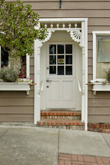 Front door entry of a Victorian cottage with gingerbread details