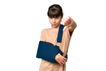 Little caucasian girl with broken arm and wearing a sling over isolated background showing thumb down with negative expression