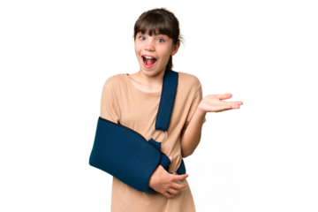 Little caucasian girl with broken arm and wearing a sling over isolated background with shocked facial expression