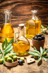 olives and oil. extra virgin olive oil jars on a wooden background. vertical image. place for text