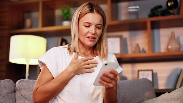 Portrait of charming middle aged woman browse products in internet store on smartphone while finds promotional sale offer and immediately reached for credit card starting to make purchase online