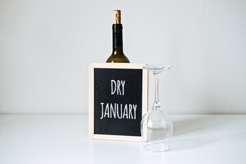 Fototapeta Dry January. Alcohol-free challenge, Health campaign urging people to abstain from alcohol for the January month. Bottle of wine, glass and sign with text Dry January obraz