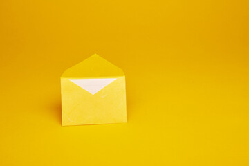Yellow color paper office envelope with white lined sheet with copy space isolated on the bright solid fond plain yellow background - obrazy, fototapety, plakaty