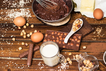Ingredients for cooking chocolate pastry from above on wooden background