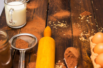 Ingredients for cooking chocolate pastry from above on wooden background