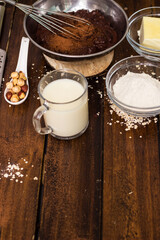 Ingredients for cooking chocolate pastry from above on wooden background