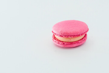 Pink French macaroon isolated on white background. Tasty colourful macarons. Cookie made of two smooth halves, fastened with stringy fillings. French pastry made from egg whites.