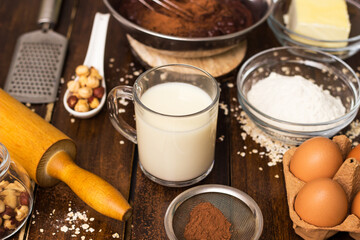 Ingredients for cooking chocolate pastry from above on wooden background