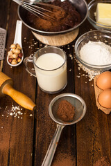 Ingredients for cooking chocolate pastry from above on wooden background