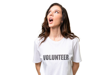 Young volunteer caucasian woman over isolated background looking up and with surprised expression