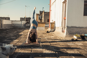 Woman Doing Yoga Outdoors On A Rooftop Terrace