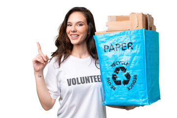 Young caucasian woman holding a recycling bag full of paper to recycle over isolated background pointing up a great idea