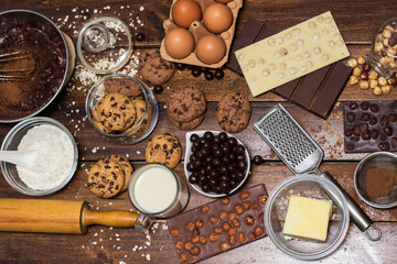 Preparing homemade chocolate chip cookies. Ingredients for preparing and baking cookies. Ingredients includes are flour, eggs, chocolates, chocolate chips, sugar,  milk,  butter, and equipment