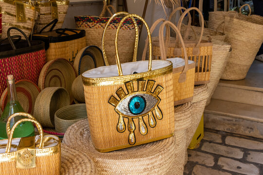 Collection of traditional wicker baskets and handmade straw bags on display at the Nabeul market, Tunisia.