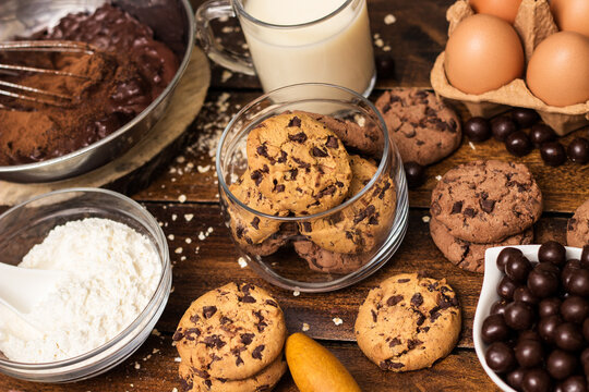 Preparing homemade chocolate chip cookies. Ingredients for preparing and baking cookies. Ingredients includes are flour, eggs, chocolates, chocolate chips, sugar,  milk,  butter, and equipment