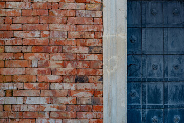 part of the decor and the material from which it is made;
part of an iron black door and a red brick wall
