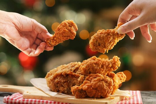 People hands taking the fried chicken wings by hands,Christmas night dinner.