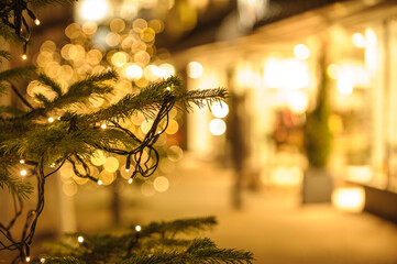 Detailaufnahme einer Lichterkette an Weihnachtsbaum vor unscharfem Hintergrund mit Bokeh