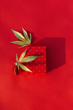 Christmas background with gift box, golden leaf marijuana red festive background