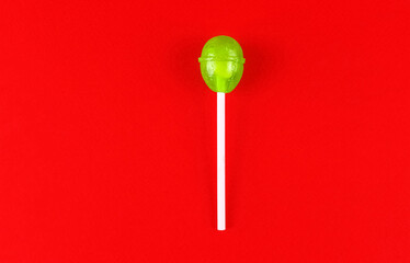 Green round lollipop on a red background