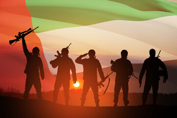 Silhouettes of soldiers on background of UAE flag and the sunset or the sunrise. Concept of national holidays. Commemoration Day.