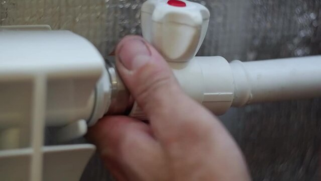 A man's hands connect a heated polypropylene pipe with a crane.Welding of polypropylene pipes with a special welding machine. Plumbing works.