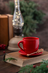 Red cup on a wooden dark table. New Year's decor. Vintage.