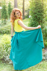 young woman in a green skirt on the lawn. smart woman