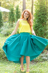 young woman in a green skirt on the lawn. smart woman