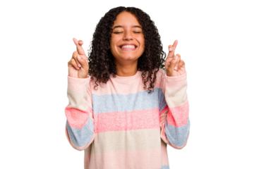 Young Brazilian curly hair cute woman isolated crossing fingers for having luck