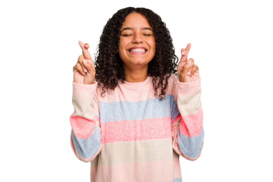 Young Brazilian curly hair cute woman isolated crossing fingers for having luck - Powered by Adobe