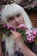 Naklejka premium young woman in flower garden in spring. female portrait