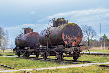Fototapeta na wymiar Two old vintage rusty petroleum oil fuel train cars wagon on railway tracks with some copy space 