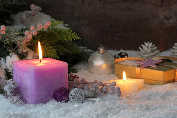 Obraz na płótnie Canvas Romantische Weihnachtsdekoration: Kerzen mit Geschenk und Weihnachtsschmuck im Schnee.