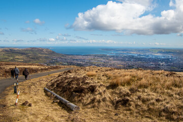 View of Belfast city from the top of Divis and The Black Mountain. People walking along the path...