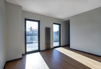empty room in an apartment with two windows to the floor