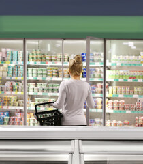 Woman choosing frozen food from a supermarket freezer