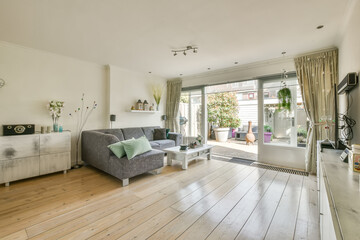 Spacious living room with corner sofa and modern TV set in daylight