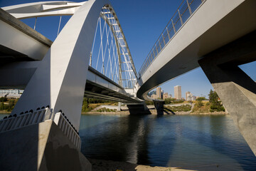 Modern arc bridge over the river, day traffic, bike road, summer time. modern architecture, panorama of the city Edmonton