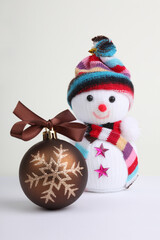 Knitting snowman and brown Christmas ball.