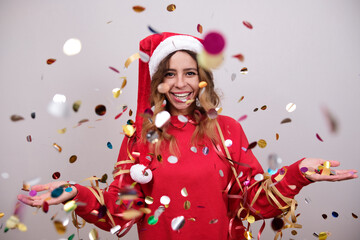 Woman in a Christmas hat with confetti.
