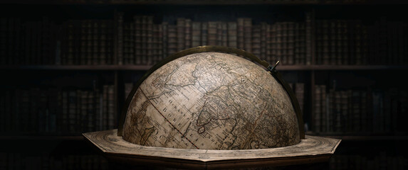Old geographical globe in cabinet with bookselfs. Science, education, travel, vintage background....