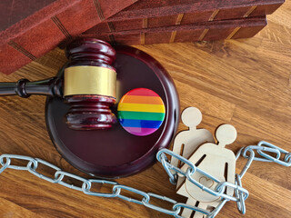 Gavel for judge lawyer on rainbow flag symbol of LGBT lesbian pride and arrest