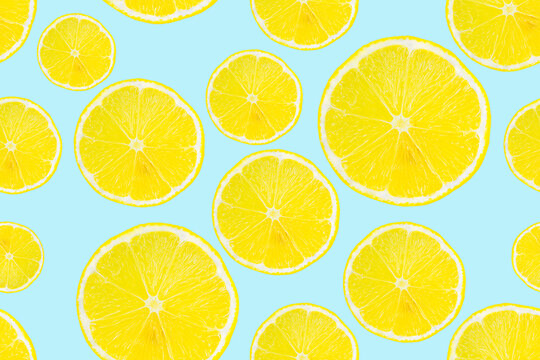 Summer seamless pattern. Lemon slices on a light blue background.