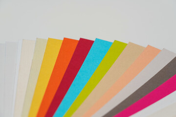 Colourful paper swatches on white desk, closeup detail