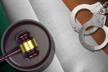 Ireland flag with judge mallet and handcuffs in dark room. Concept of criminal and punishment,...