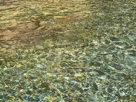 Sea water aqua pebbles beach.
