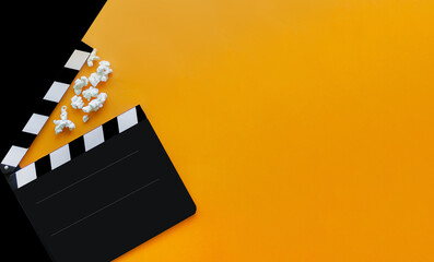 
stylish mockup with clapperboard in black and orange colors. copy space, space for text. top view. flat lay style. concept cinema party, film industry, movie premiere