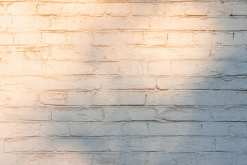 White brick wall background with abstract shadow from the sunset light. Architecture element, masonry, brickwork grunge stone structure. Wallpaper, backdrop