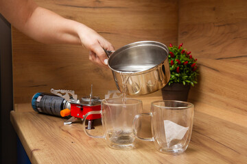 girl pouring hot water into cups